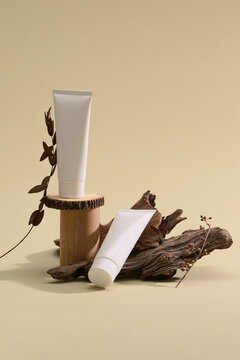 A serene product shot of cosmetic tubes with wood and natural backdrop