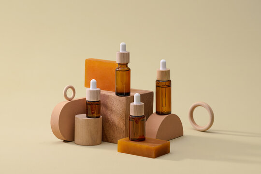 Cosmetic bottles and wooden props against a soft beige