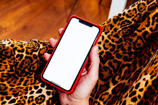 a close-up of a man holding a blank phone with a red case