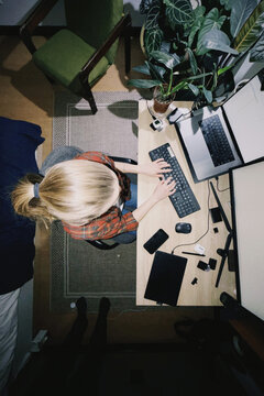 Woman working from home using computer setup overhead