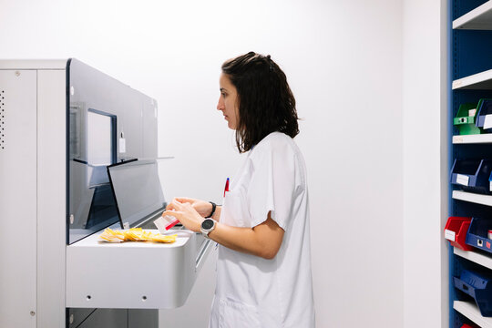 Pharmacist preparing medication using an automated dispensary system