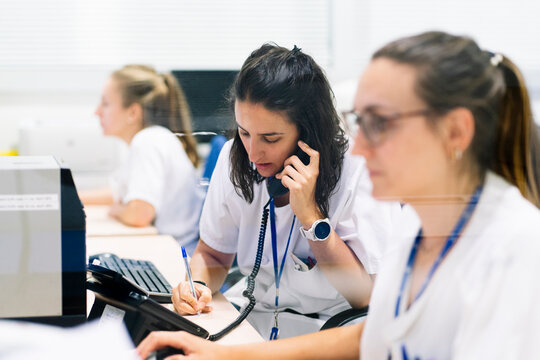 Pharmacist woman communicating on phone in hospital pharmacy