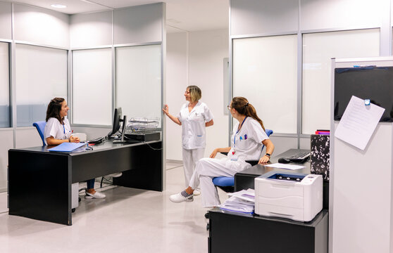 Healthcare workers discussing workflow in hospital pharmacy department