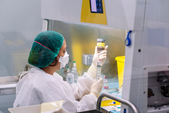 Pharmacist preparing sterile medicine in laboratory laminar flow hood