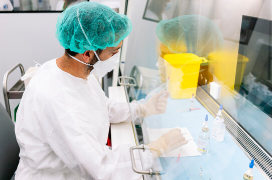 Pharmacist preparing sterile IV medication in a laminar flow hood