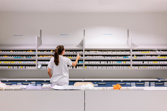 Female pharmacist organizing medication in hospital 