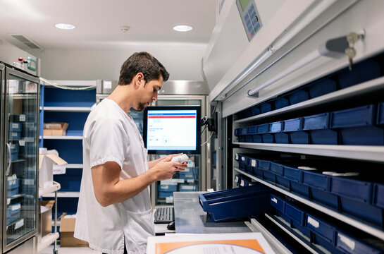 Pharmacist using automated dispensing system in hospital pharmacy