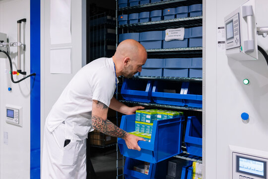 Pharmacist organizing medication inventory in hospital pharmacy