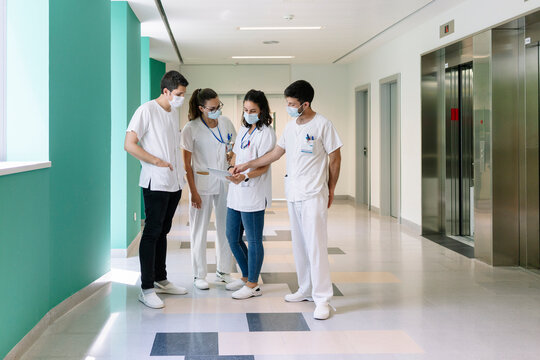 Medical staff collaborating in hospital pharmacy department hallway