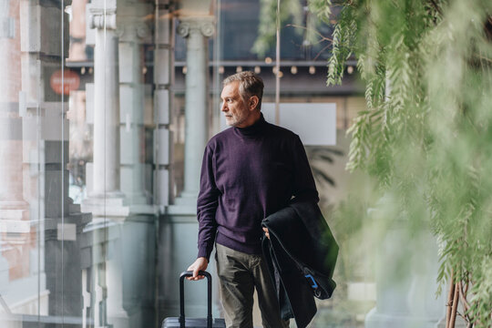 Businessman checking in hotel lobby with luggage