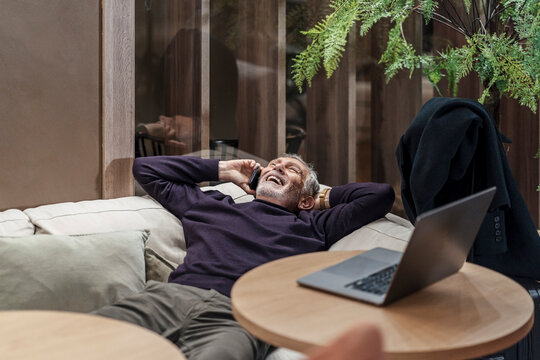Senior man relaxing and laughing during phone call