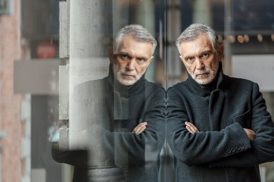 Mature man reflecting on hotel arrival looking serious