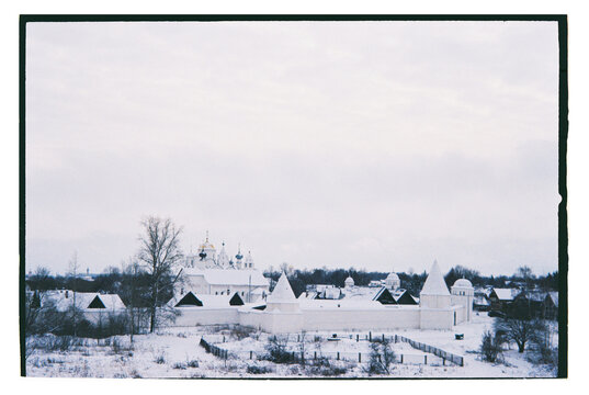 Winter landscape featuring a village with white buildings 