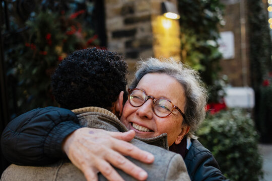 Loving grandmother embracing son during winter holidays
