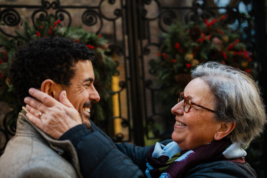 Loving grandmother embracing son during winter holidays