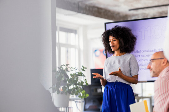 Female Presenter Leads Office Presentation In Modern Meeting