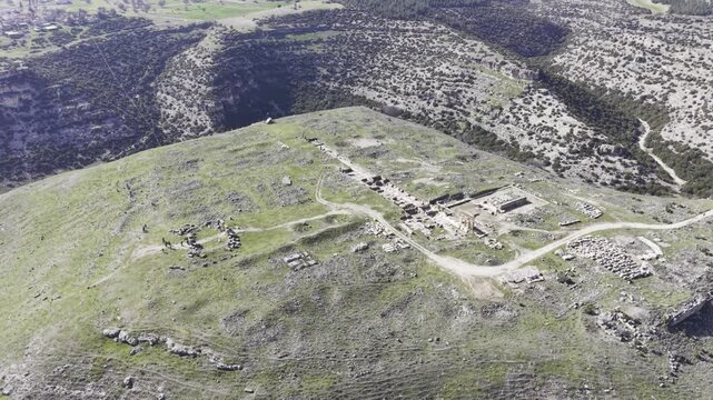 Cinematic aerial drone video footage of Blaundus Ancient City near Ulubey in Usak, Turkey, featuring ancient ruins, stone structures, and dramatic landscape from above in the Aegean region.