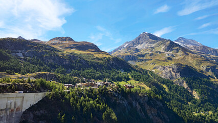 Fototapeta premium Alpine village at Barrage du Chevril, French Alps, Savoie, France, Europe. Alpine village surrounded by mountains at Barrage du Chevril, French Alps, Savoie, France, Europe.