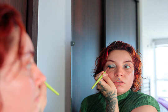Woman Applying Eyeshadow in Bedroom Mirror