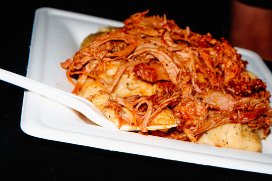 close-up of polenta with pulled pork on a disposable plate
