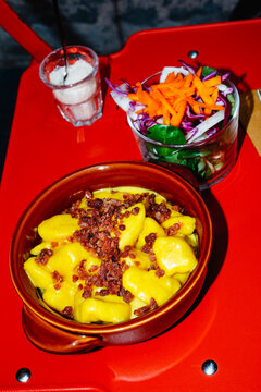 a clay dish of gnocchi with Parmigiano Reggiano and prosciutto