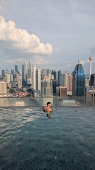 Fototapeta premium Serene luxurious rooftop pool escape in metropolitan Singapore Kuala Lumpur metropolis, man enjoying stunning skyline panoramic view of skyscraper city center urban architecture in Asia