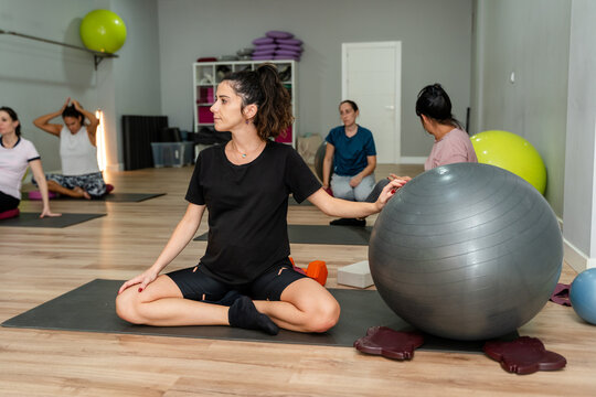Prenatal yoga class seated twist with stability ball