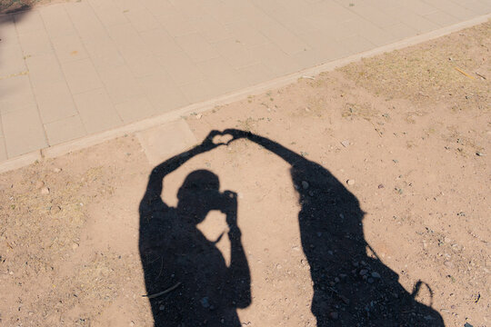 Shadow of a couple forming a heart with their hands