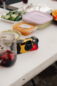 Disposable camera on picnic table with food and drinks