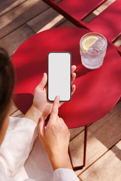 Woman using smartphone at red cafe table during summer travel