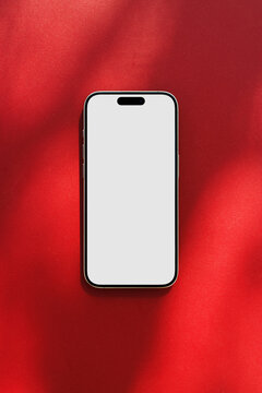 Smartphone with blank screen on red background