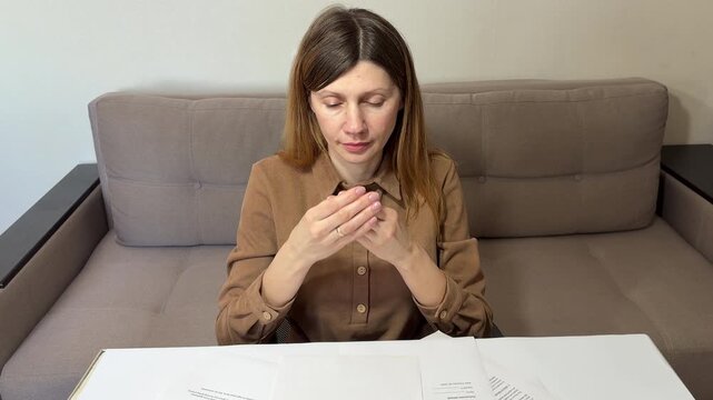 Happy woman holding house key near chest, emotional moment of buying a new home