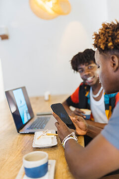 Two men using modern technology in cafe in Stone Town