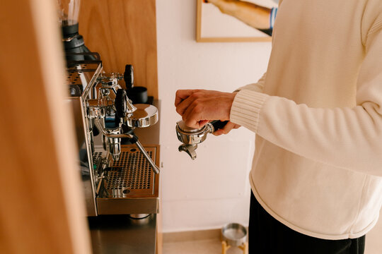 Anonymous man preparing coffee at home on a quiet morning