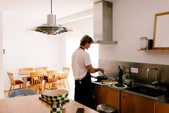 Wide view of a man preparing a healthy breakfast in a compact kitchen