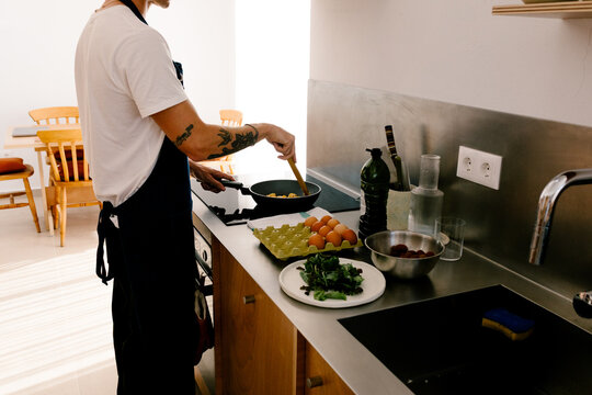 Unknown man preparing healthy breakfast in a small minimalist kitchen