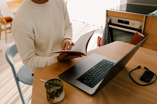 Modern unknown man working from home in bright architectural space