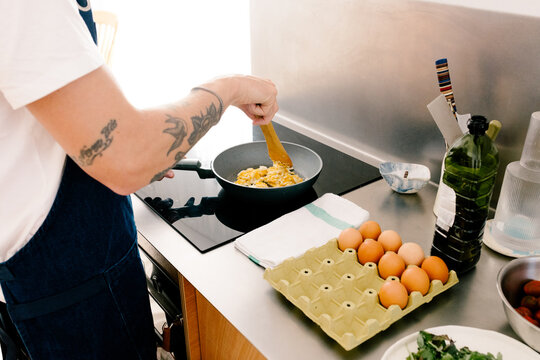 Anonymous man&rsquo;s hands cooking a healthy meal on an induction stove
