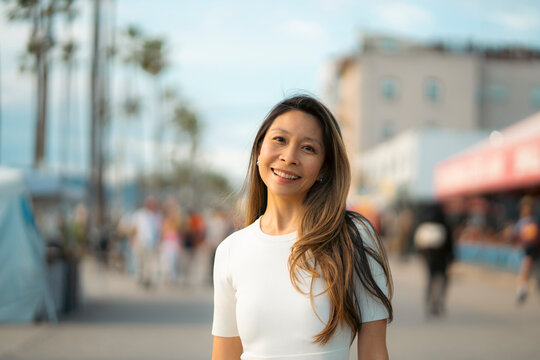 Woman smiles at the beach boardwalk
