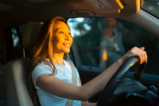 Woman driving a car at sunset
