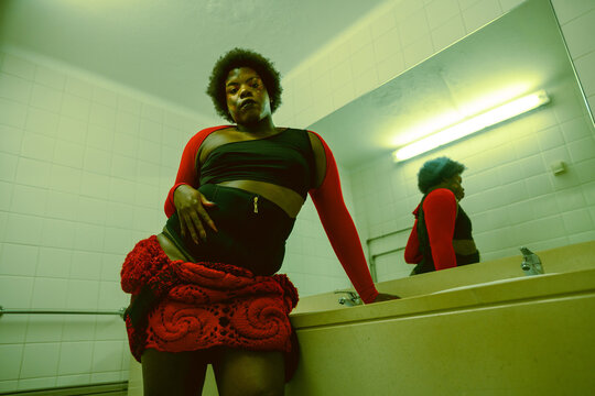 Person Posing in a Restroom With a Mirror in the Background
