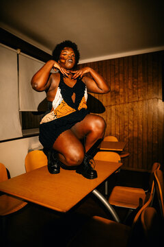 Person Stands on Table in Classroom Setting During Evening