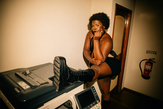 Person Poses on a Copier in a Hallway at Night