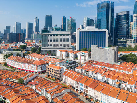Lines of row houses with terracotta tiled roofs below city skyscapers