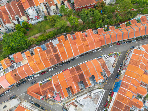 Lines of row houses with terracotta tiled roofs alongside parkland