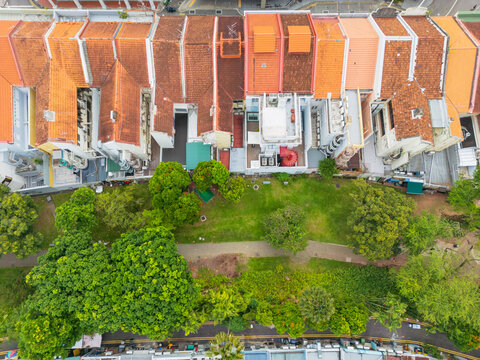 Lines of row houses with terracotta tiled roofs alongside parkland