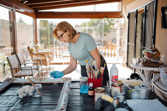 Senior woman painting a frame