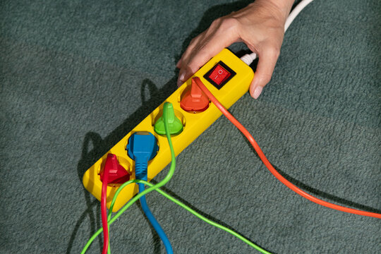 Hand Holding Power Strip with Colorful Cords
