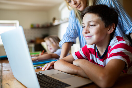 Mother helping children with online learning at home
