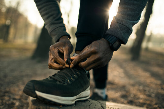 Runner tying shoelaces on park trail